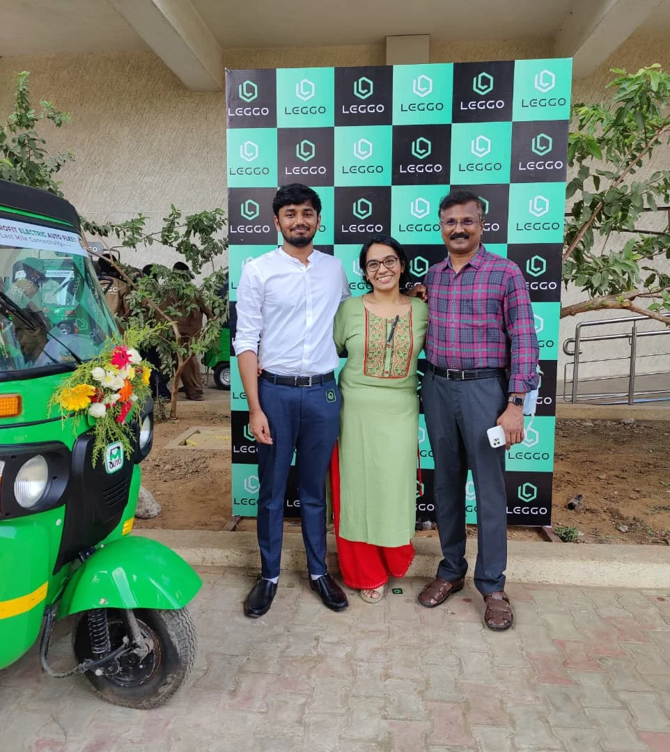 Three of the Leggo team at the Leggo launch backdrop beside a garlanded auto