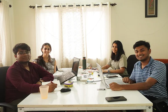 The team at a shared table with laptops