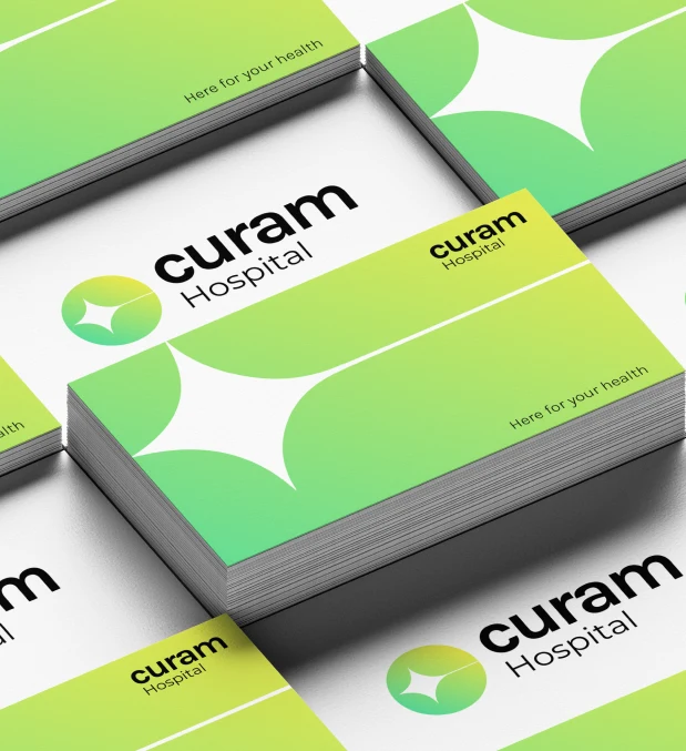 Stacks of green Curam Hospital business cards